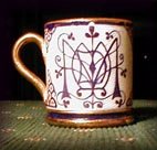 A small cup decorated by Arthur Midgley