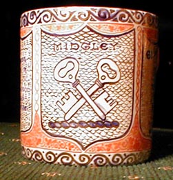 A mug painted about 1914 by Arthur Midgley of a crest crossed keys wards down.
